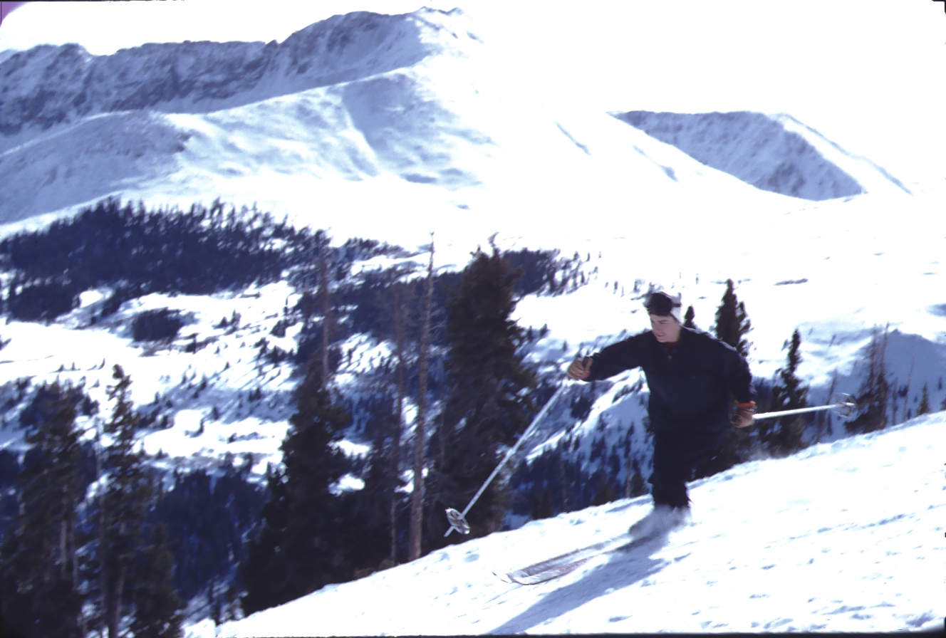 Vintage color photo of a woman skiing downhill at Climax ski area in front of Mount Arkansas