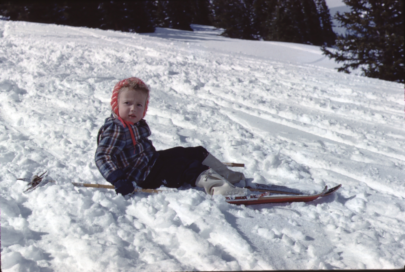 Vintage photo of a little girl who has fallen off her skis.