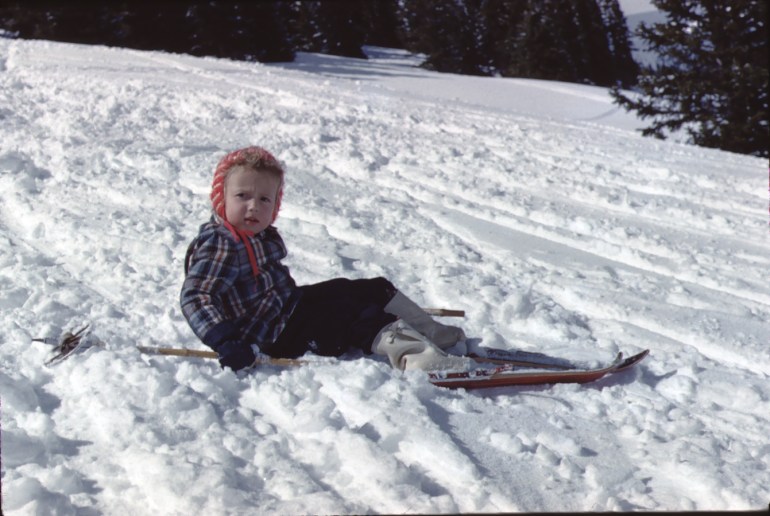 Vintage photo of a little girl who has fallen off her skis.