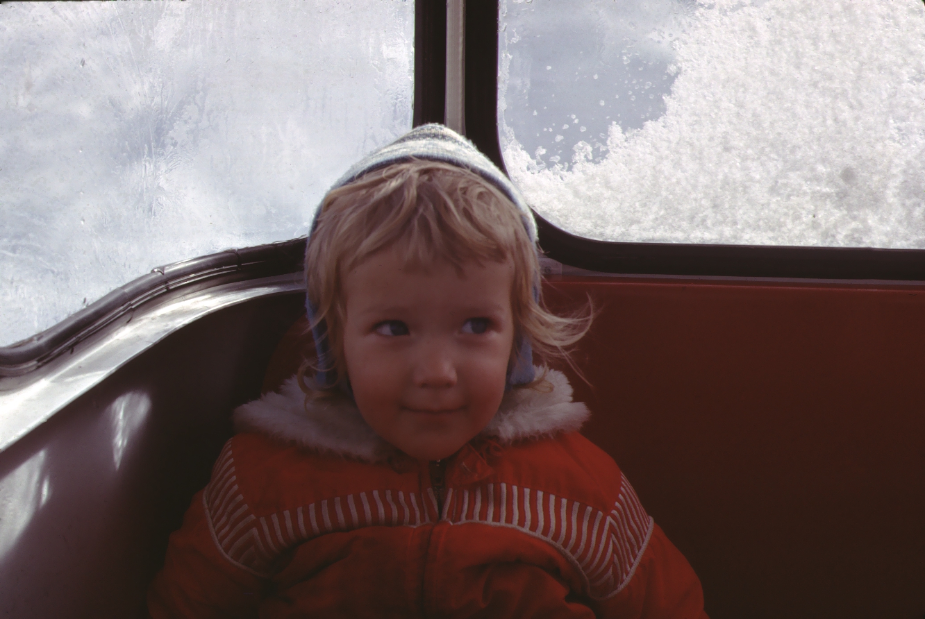 Vintage photo of a little girl riding in a ski gondola